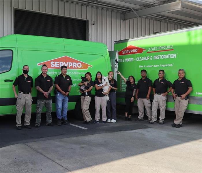 SERVPRO employees standing in front of company vehicles